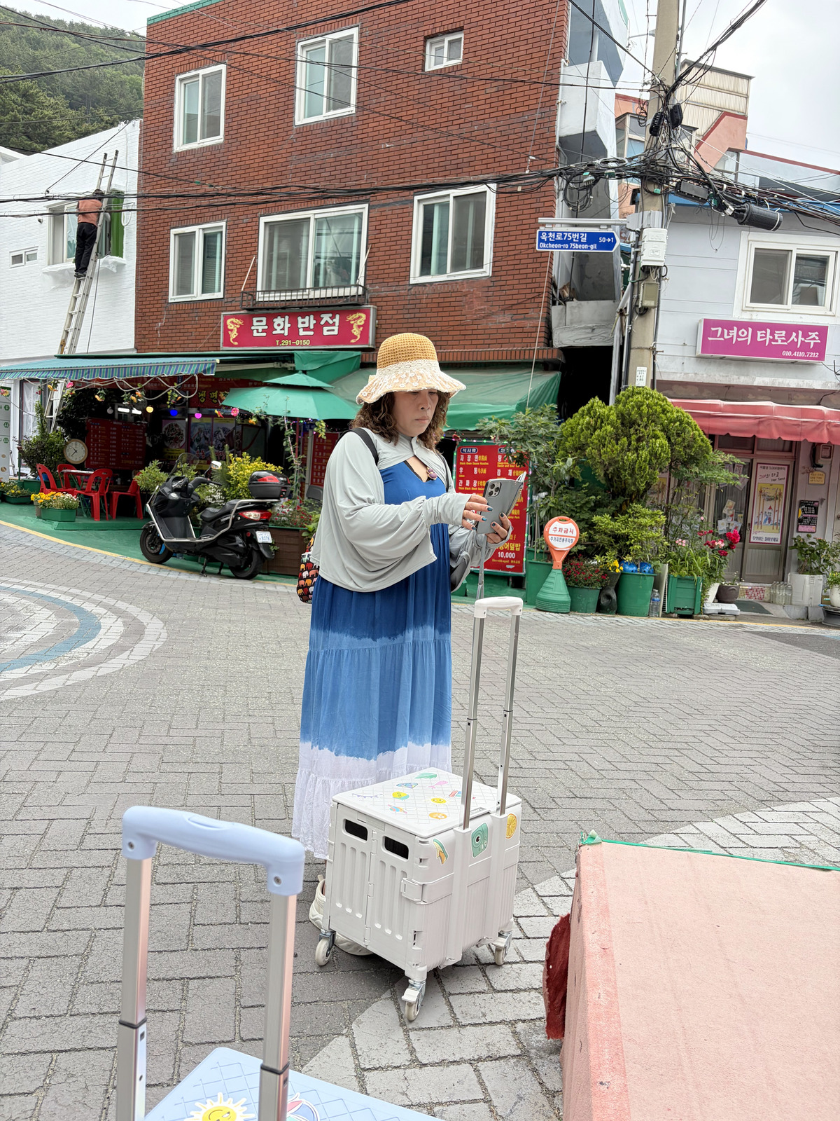 阿姨在甘川文化村推著行李車