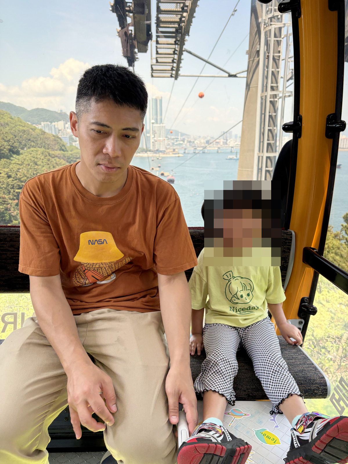爸爸和孩子坐在海上纜車車廂裡