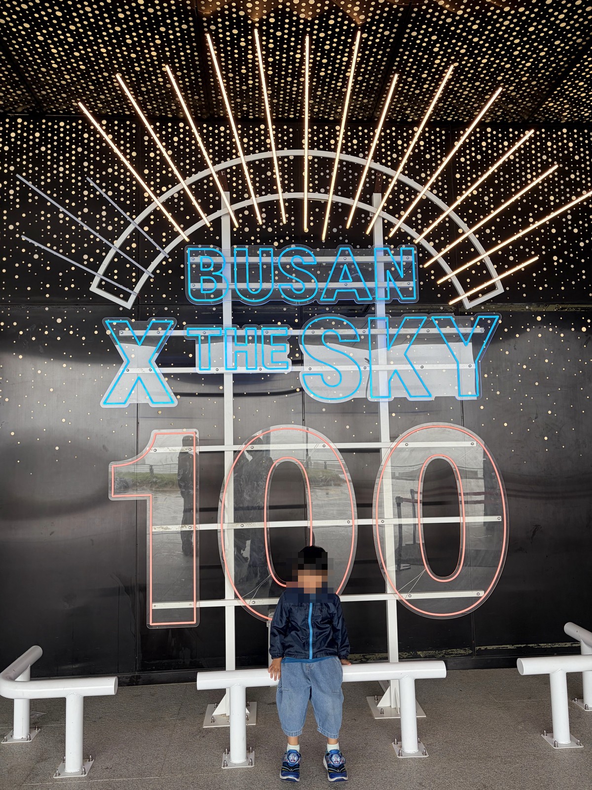 孩子站在BUSAN X the SKY 100樓燈光裝置拍照點前