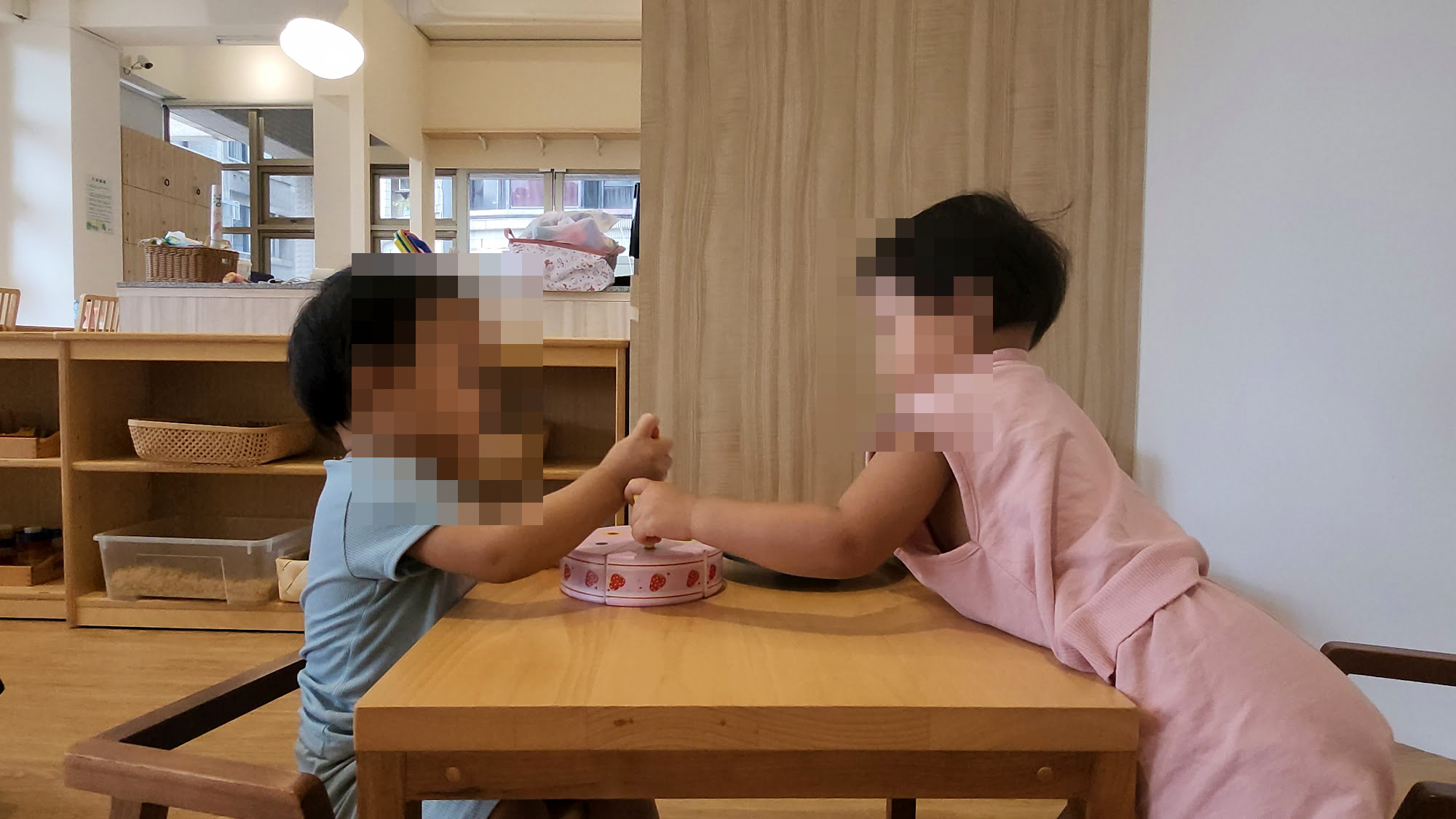 兩個孩子在小桌子上玩玩具蛋糕