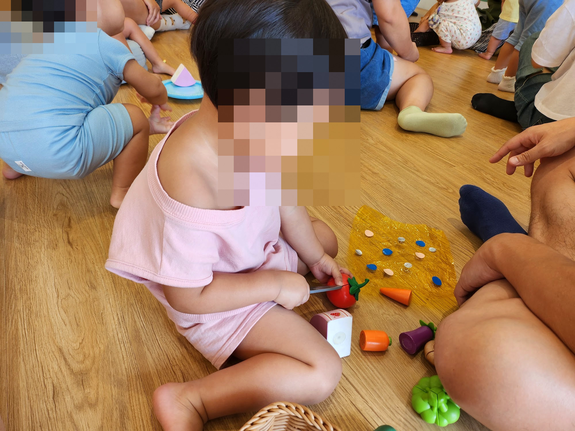 孩子坐在地墊上玩切蔬菜的玩具