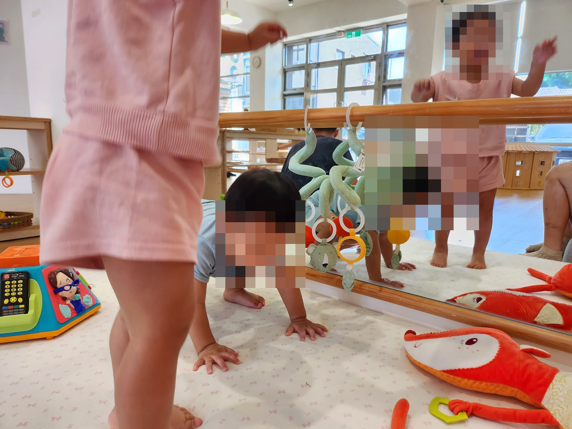 孩子在鏡子前的軟墊上爬來爬去