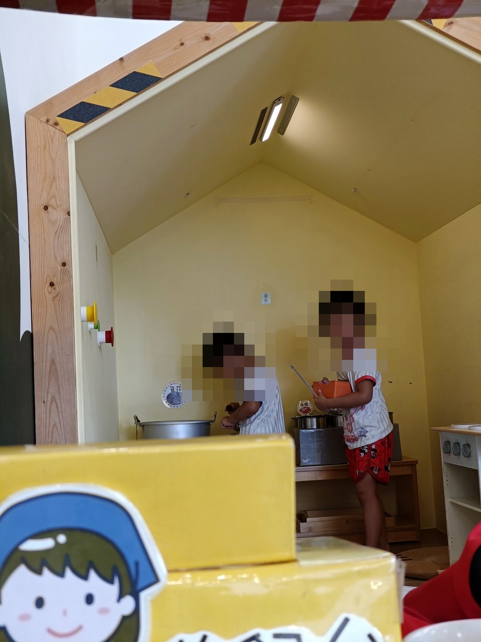 兩個孩子在大溪親子館小屋裡玩煮飯遊戲