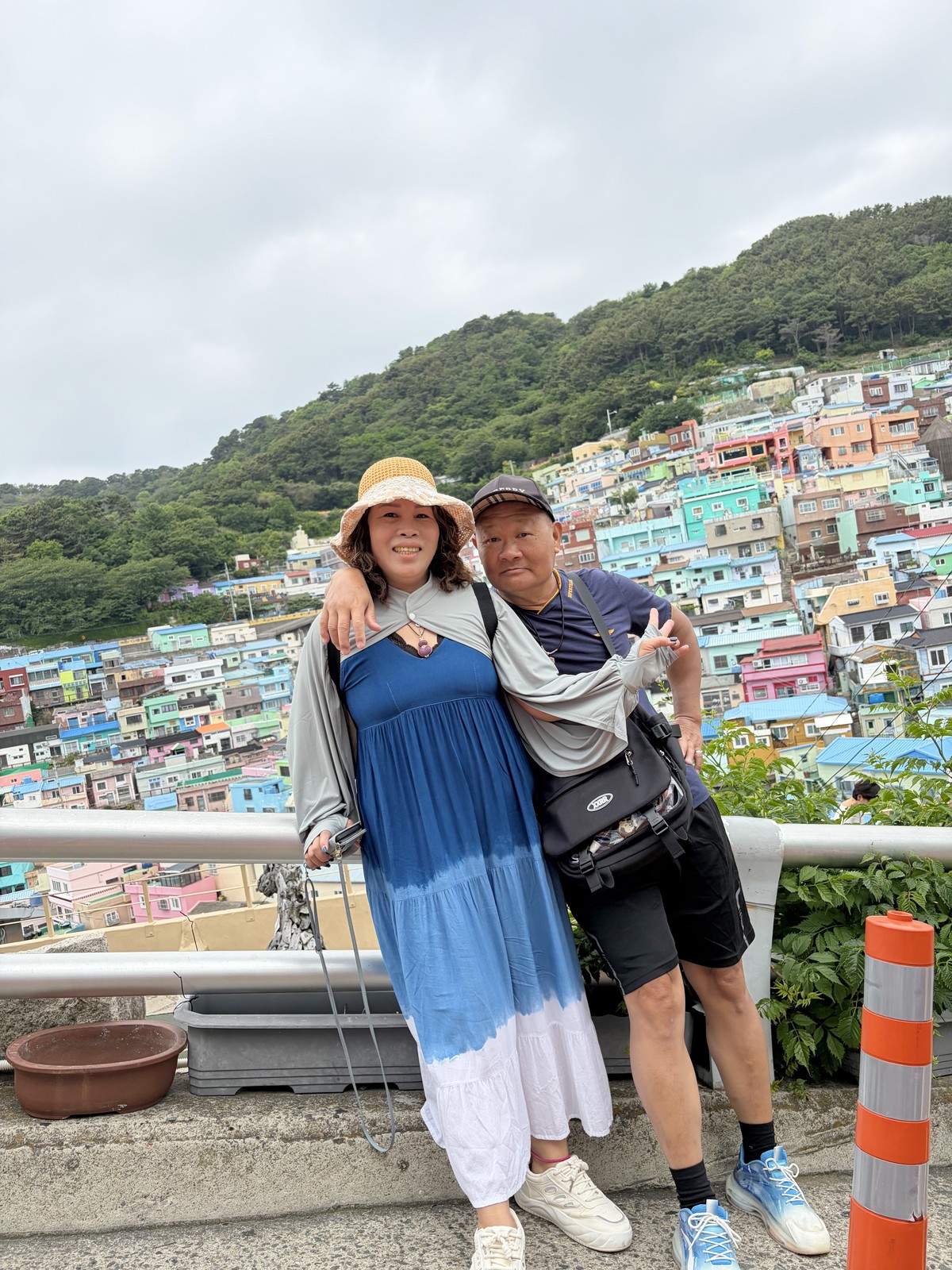 家人站在甘川文化村觀景點前，背後是彩色山城