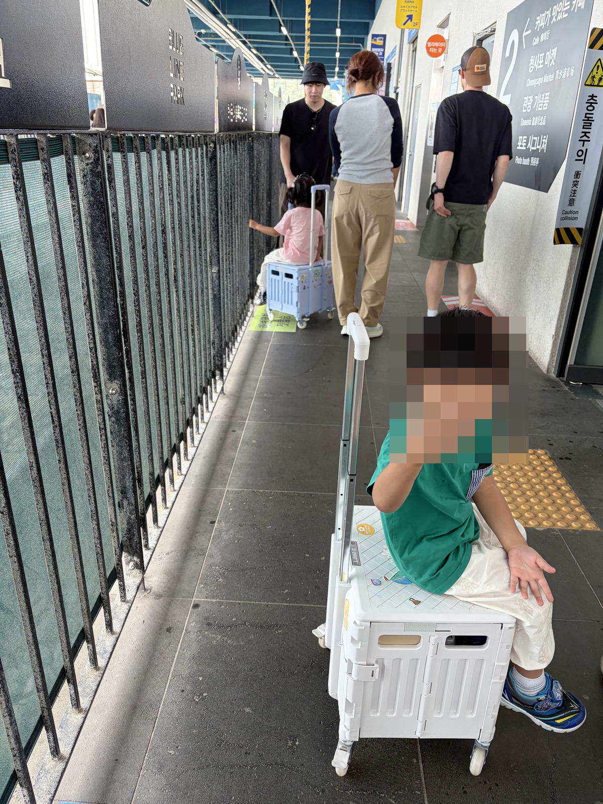 樂坐在藍線公園月台的行李推車上排隊