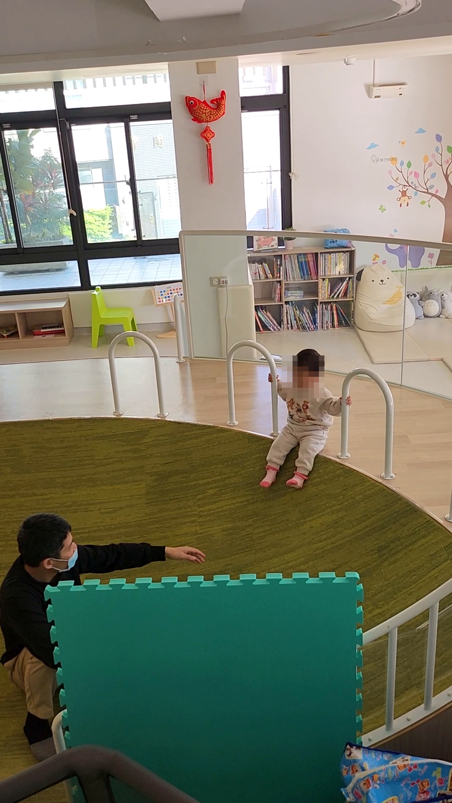 北區親子館的綠色草地造型遊戲區與扶手步道(孩子臉部已打馬賽克)