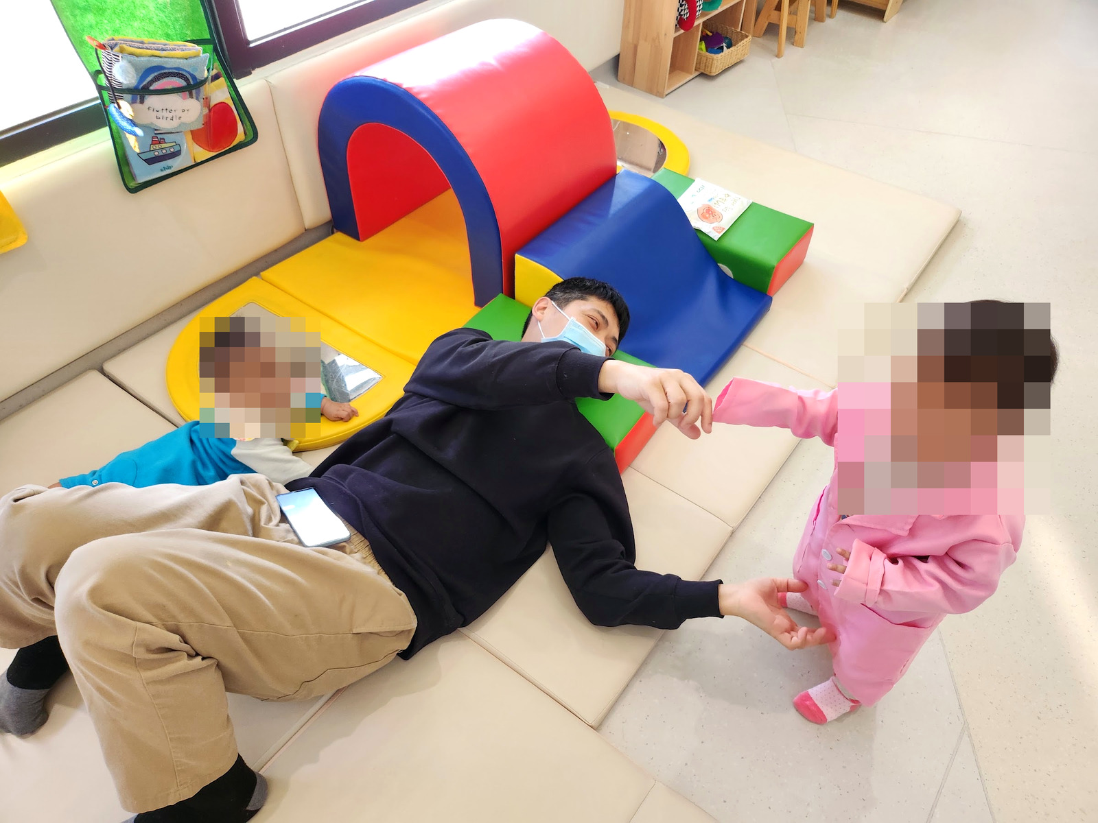 孩子和大人在北區親子館的軟墊隧道旁一起玩(孩子臉部已打馬賽克)