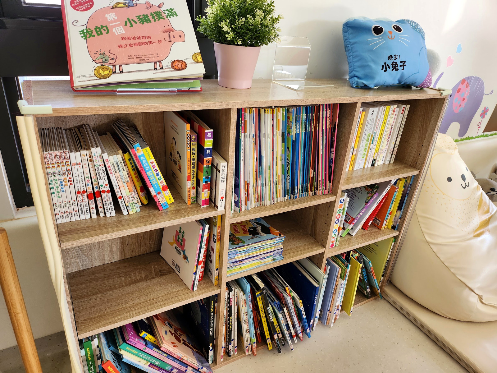 新竹市北區親子館的親子閱讀區,木書櫃上擺滿童書與繪本