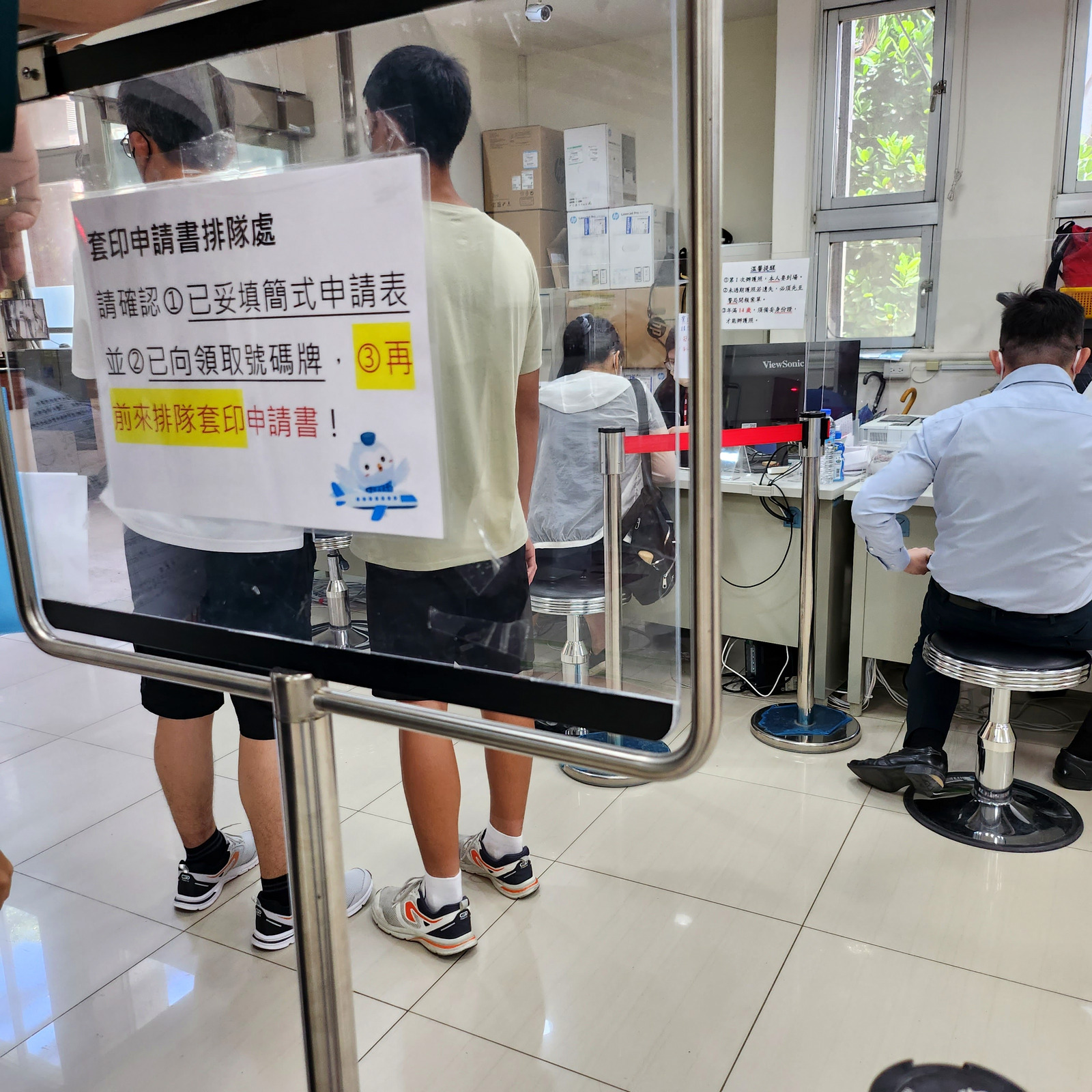 套印申請書排隊處的指示牌與排隊民眾