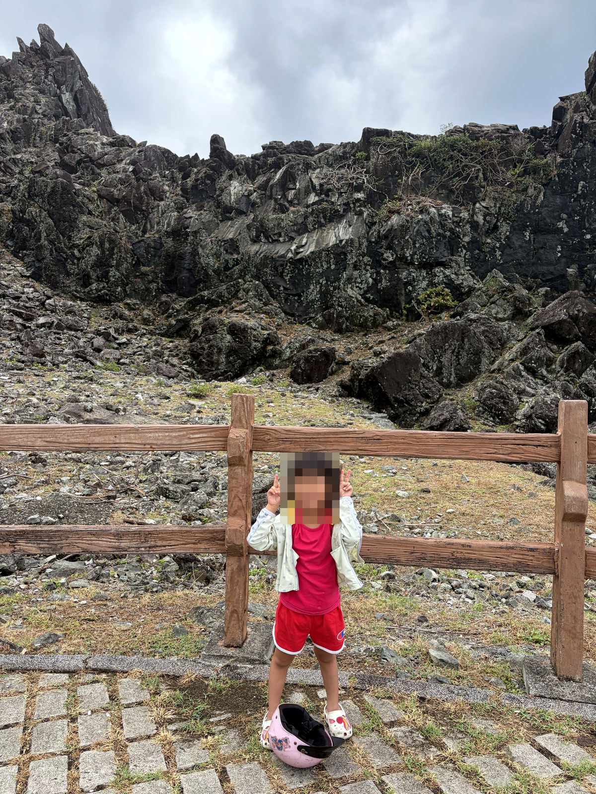 女兒在蘭嶼黑色火山岩前比耶