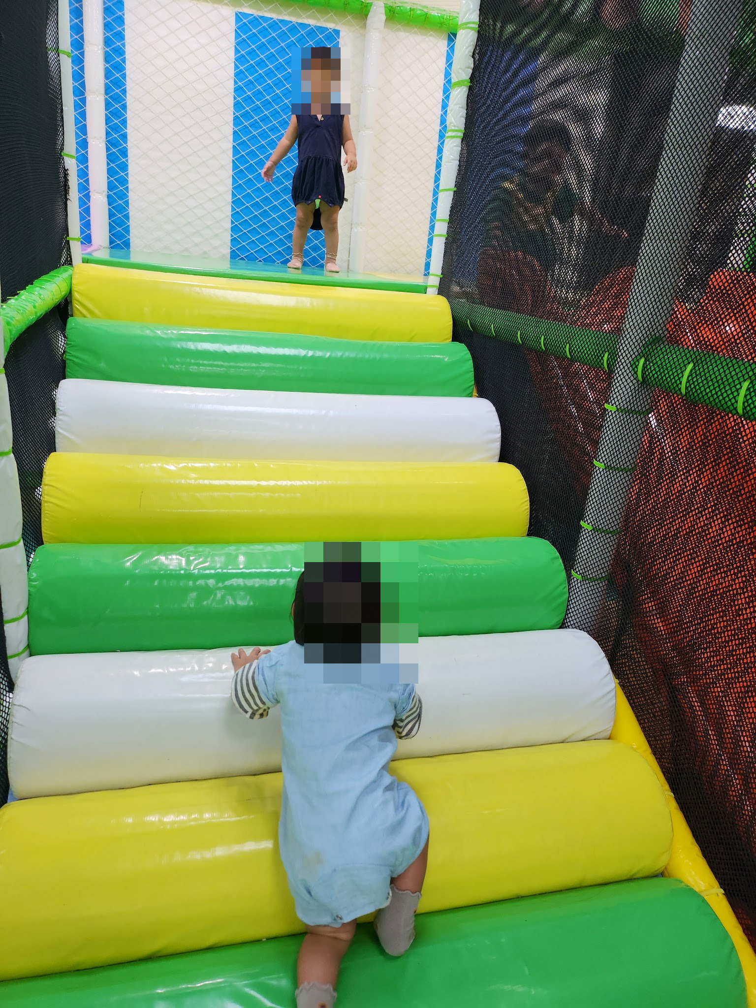 孩子爬上台中北區運動中心兒童遊戲區的彩色軟墊階梯