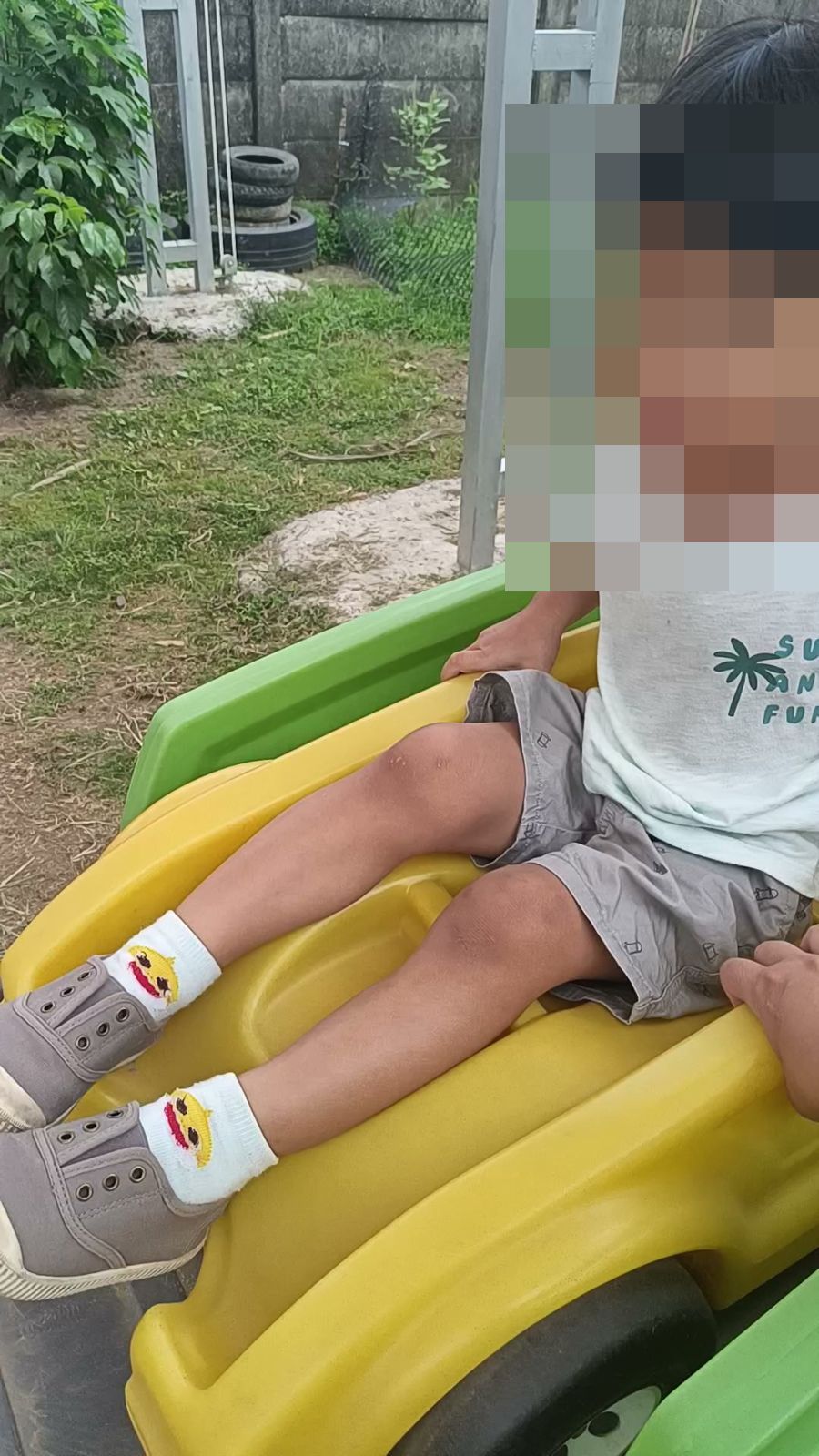 孩子坐在給小孩戶外的黃色滑車上