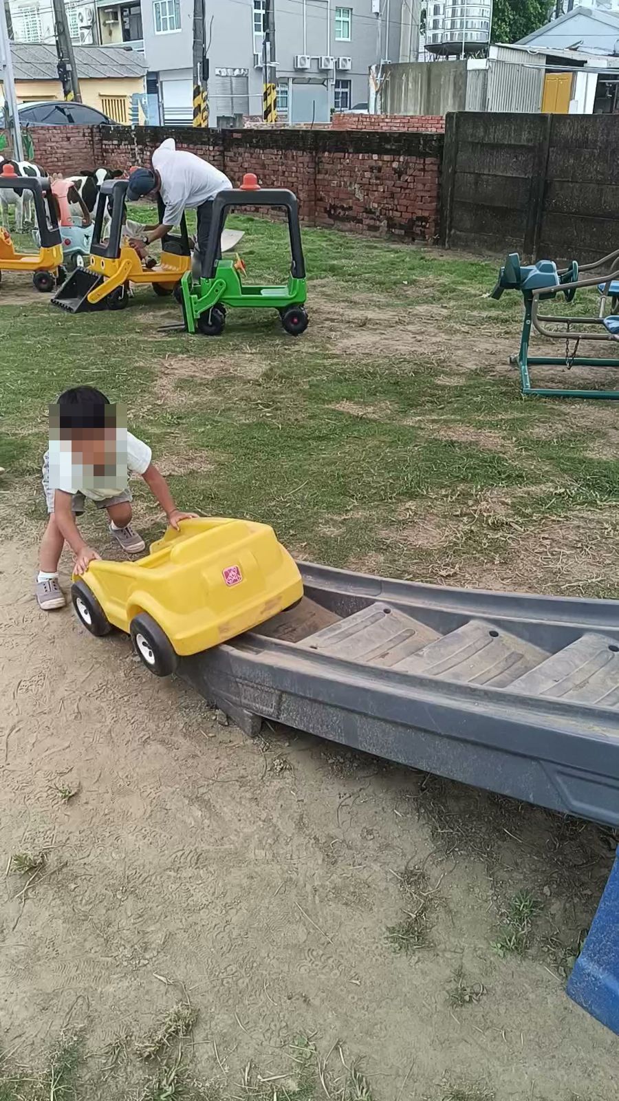 孩子在給小孩親子餐廳戶外坐滑車